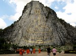 Lots of tiny monklets dwarfed by Giant Buddha